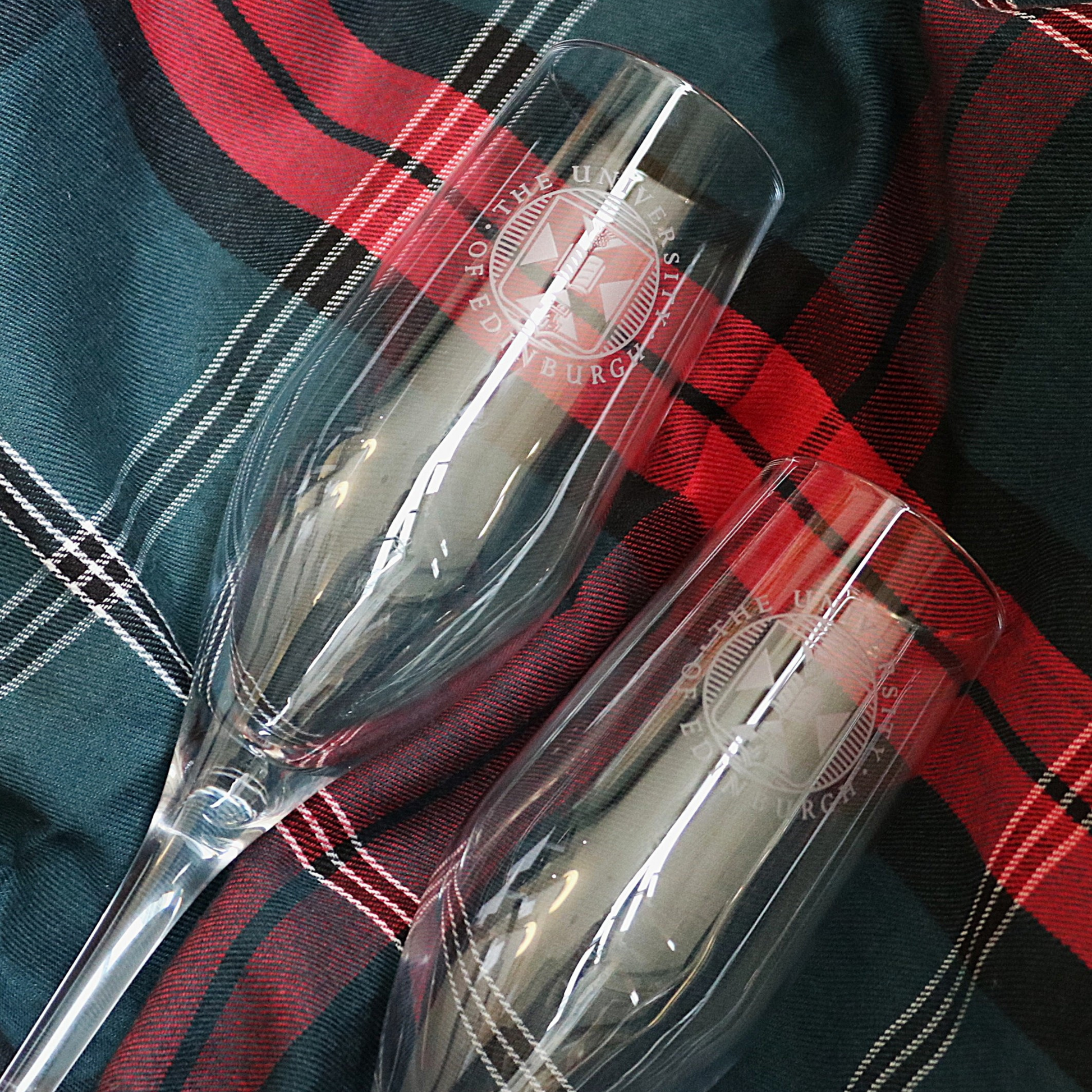 Champagne flutes pictured against a University tartan backdrop.