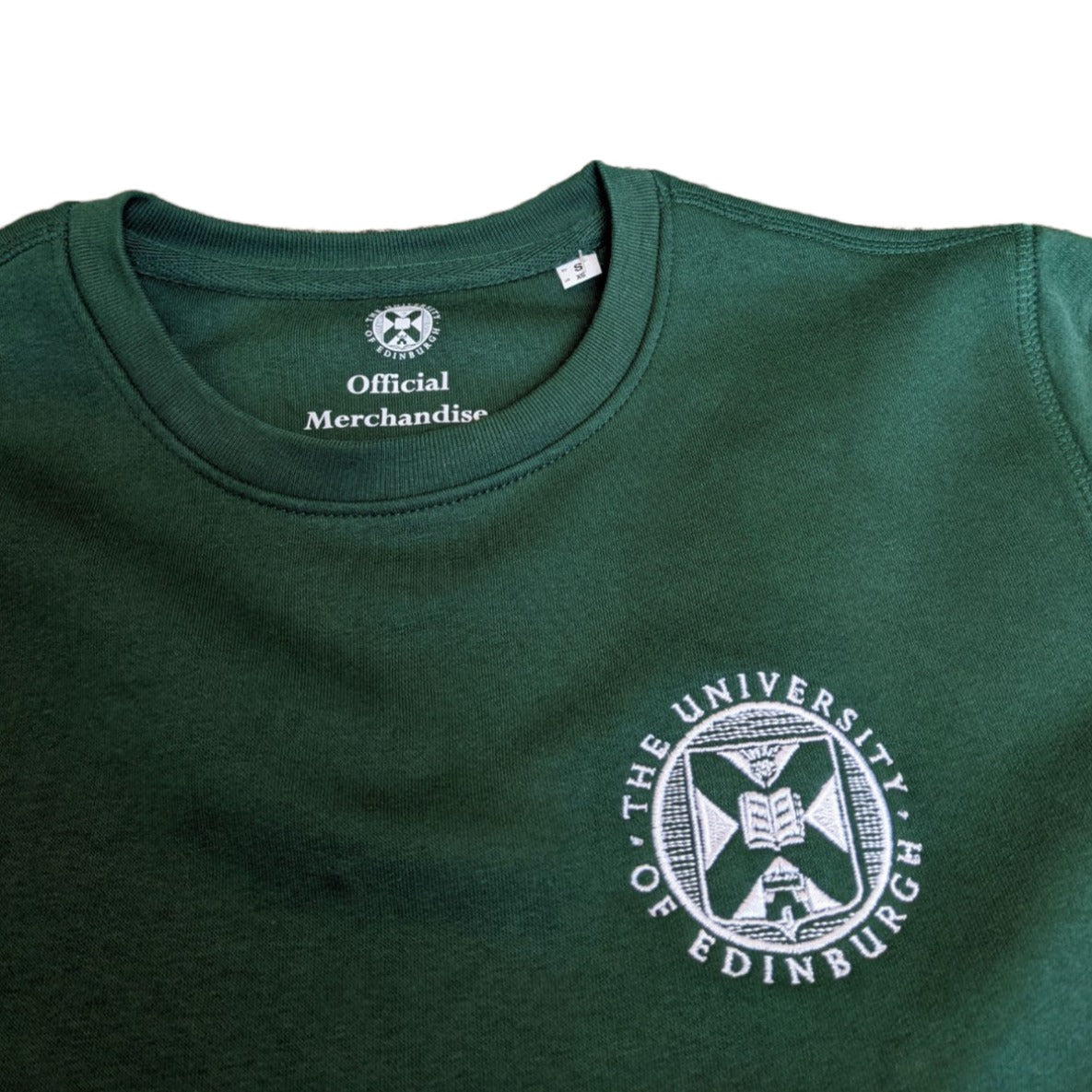 close up of premium bottle green sweatshirt with white embroidered university crest 