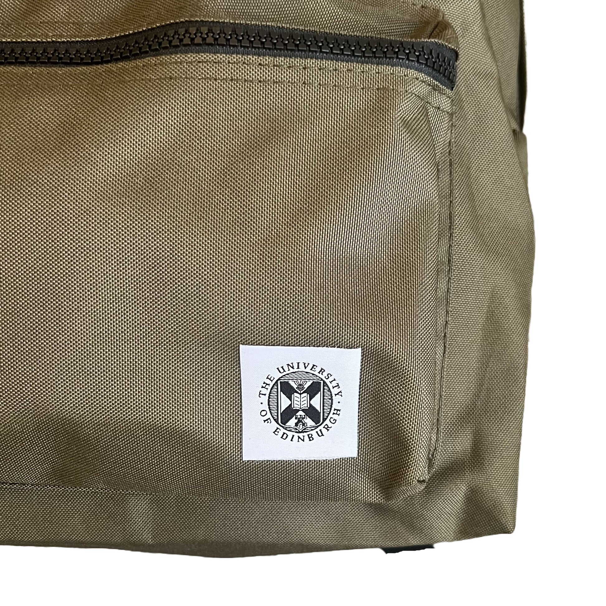 Close up of the University of Edinburgh's crest stitched onto a khaki backpack.