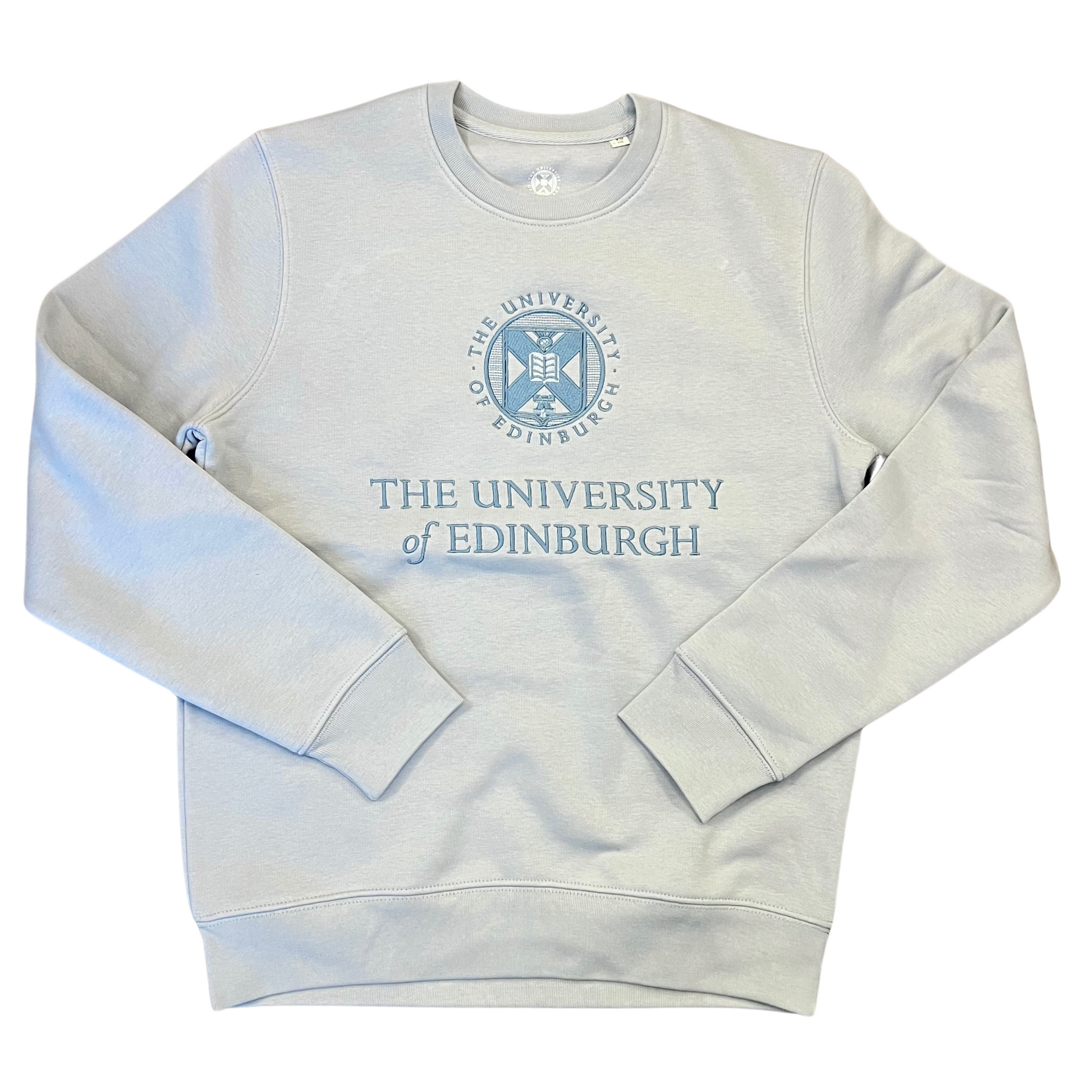 light blue tonal crewneck sweatshirt with a blue embroidered university crest and name in the centre of the sweater