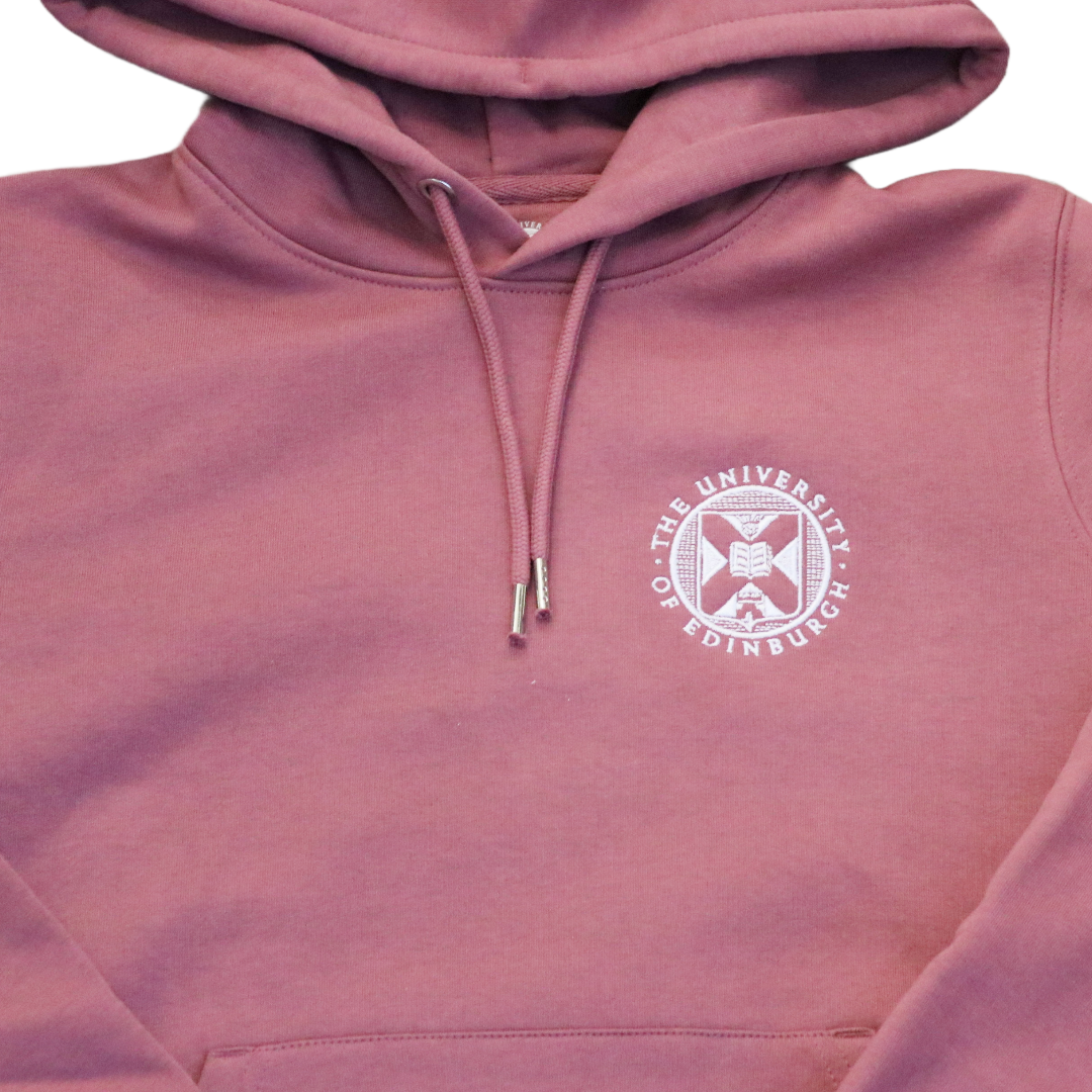 a close up of the white embroidered university crest on the hibiscus pink hoodie