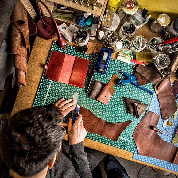 A man in a leather workshop seen from above while working on the products