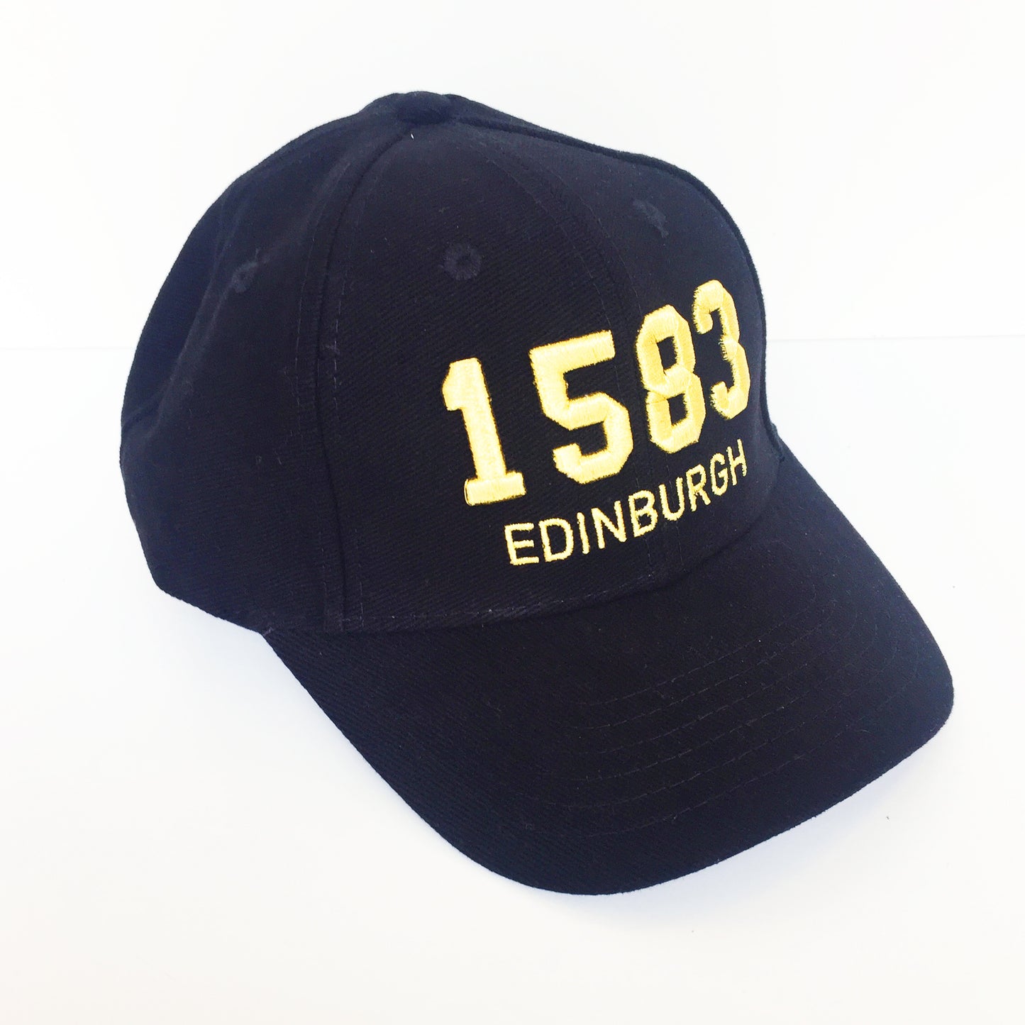 Black cap with '1583 Edinburgh' on the front panel in gold embroidery. 