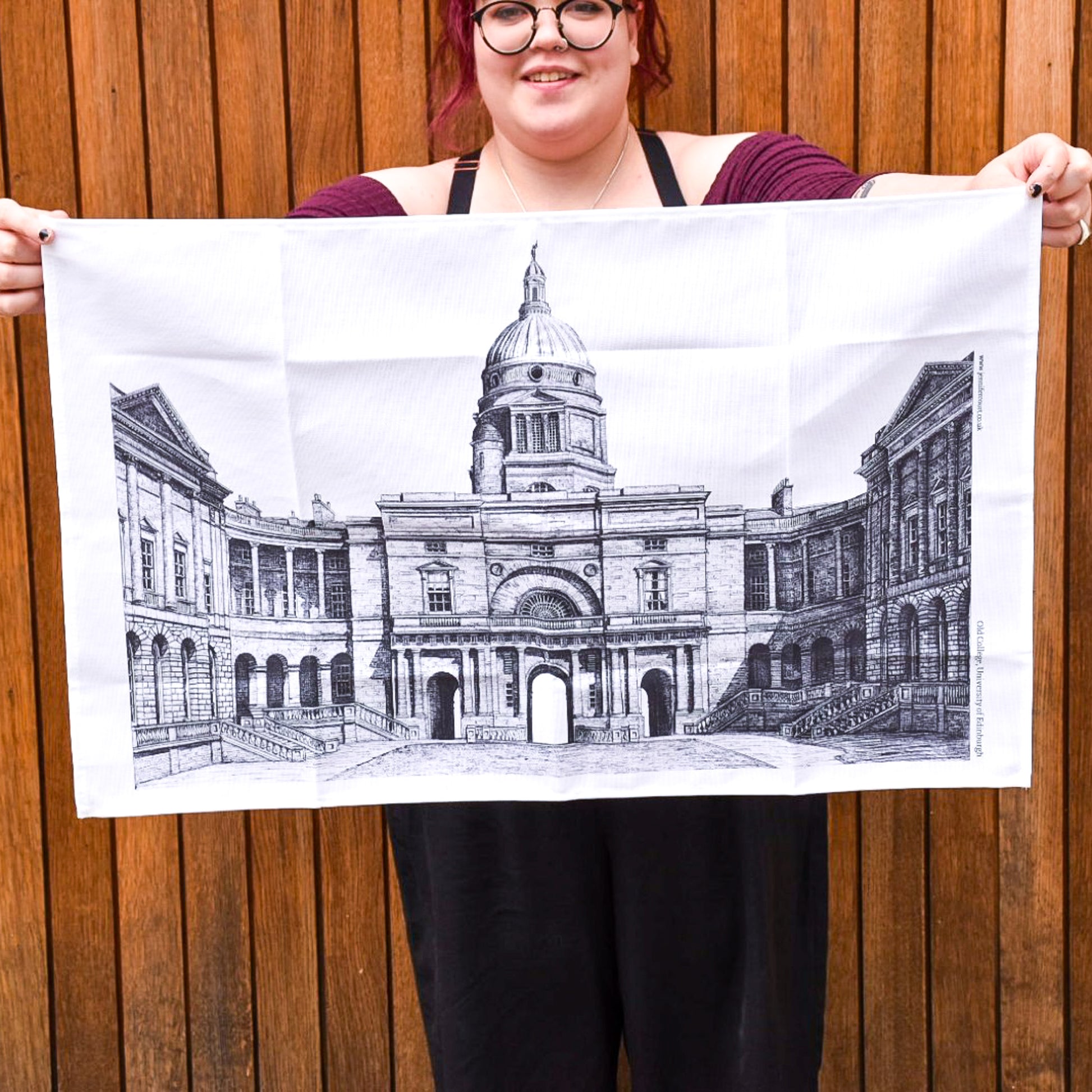 Black and white image of Old College on a white tea towel held by a model
