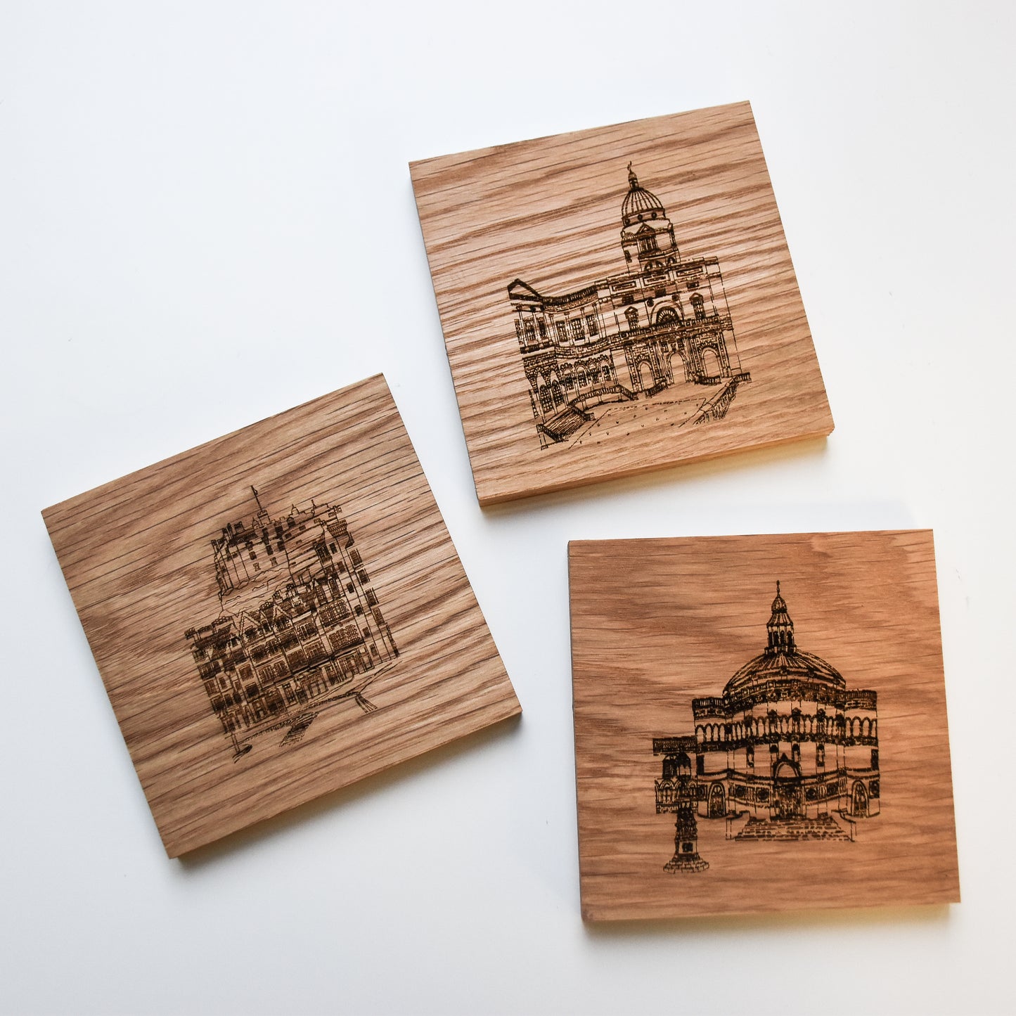 Wooden coasters featuring engraved illustrations of Old College, the Castle & Mcewan Hall 