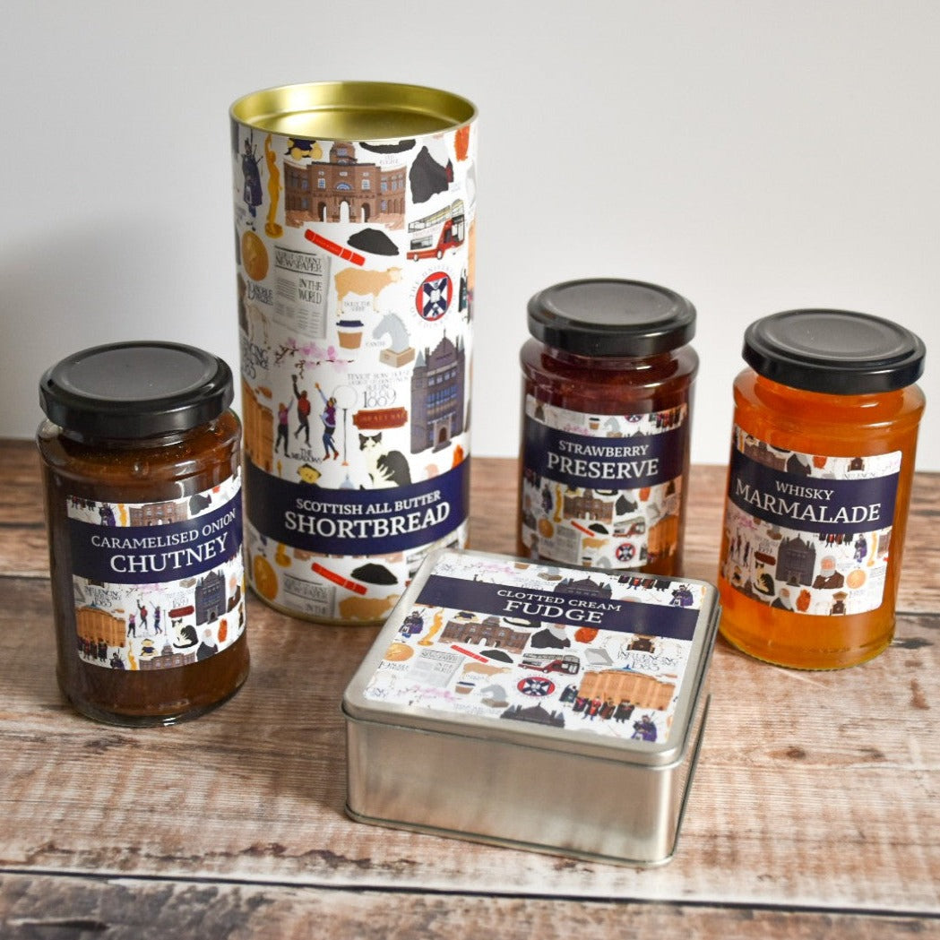 Collection of Clotted Cream Fudge, Scottish All Butter Shortbread, Caramelized Onion Chutney, Strawberry Preserve, and Whisky Marmalade containers.