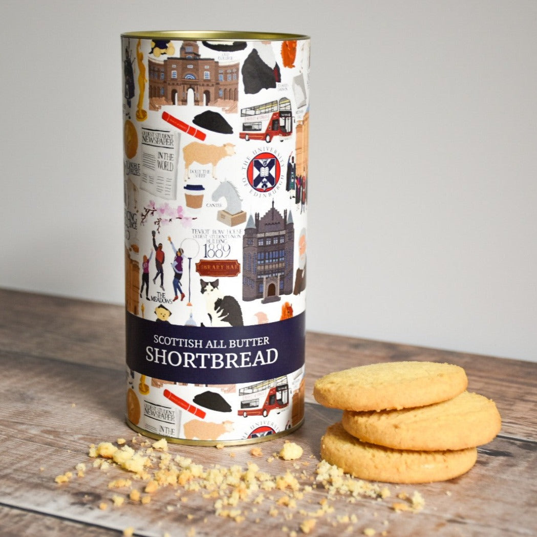 Scottish All Butter Shortbread tin container positioned next to an arrangement of shortbread cookies.