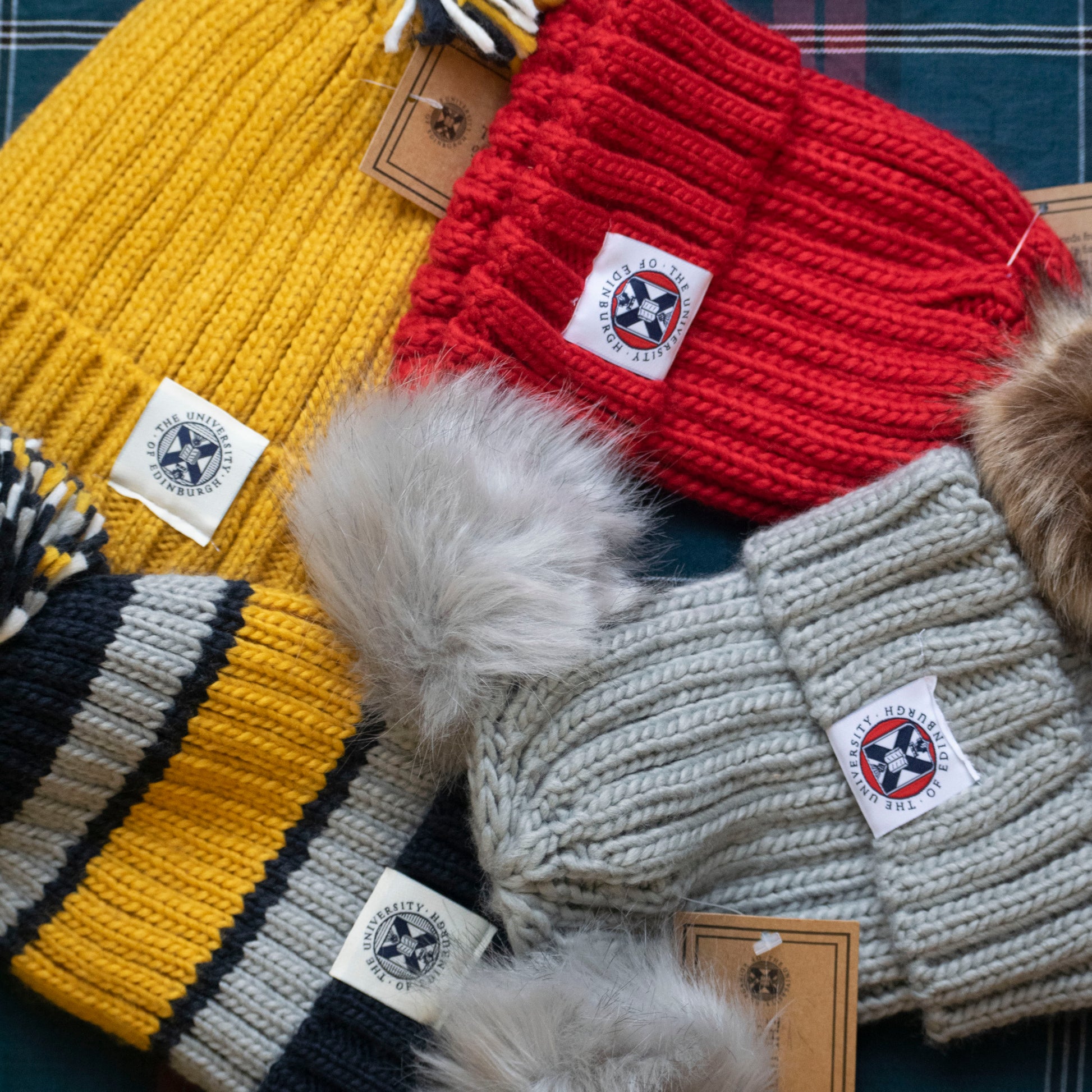 a collection of out hats including : The Double Pom Pom Hat, The Varsity Striped Pom Pom Hat, The Red Faux Fur Pom Pom Hat and The Pom Pom Hat in Mustard Yellow. 