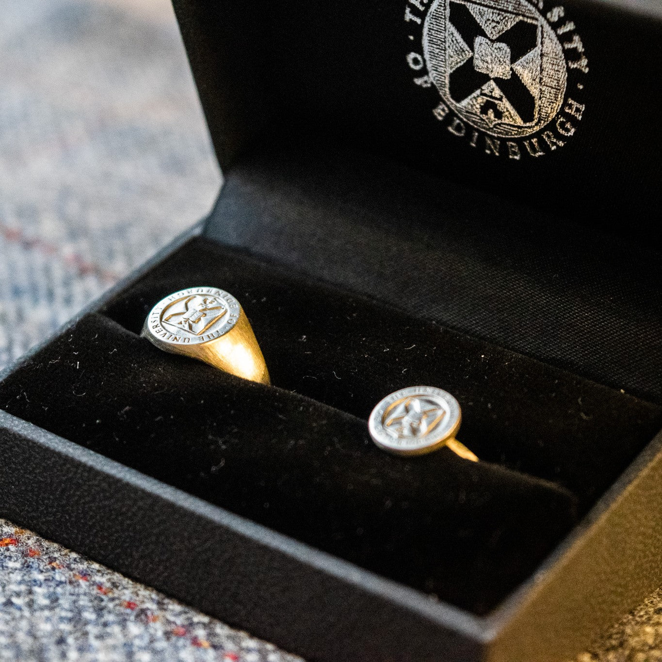 Silver crest on band and signet ring in silver in a ring box