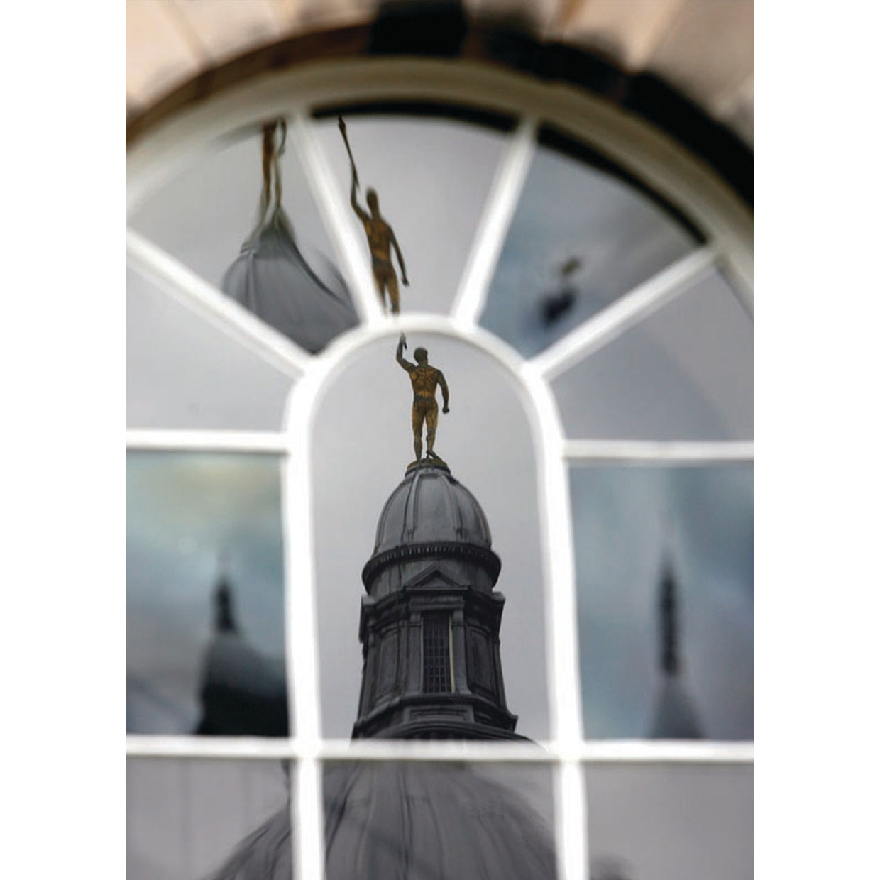 Photograph of Golden boy reflecting in a window