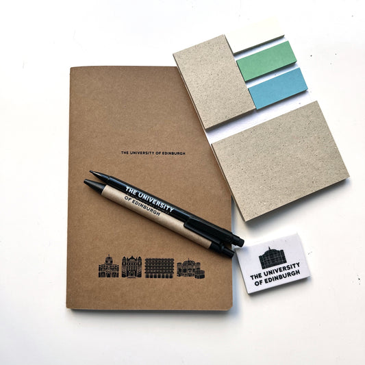 A5 kraft notebook with 'The University of Edinburgh' and University building illustrations of the cover in black print. Pictured with seeded sticky notes, mechanical pencil, recycled cardboard pen and mcewan hall eraser