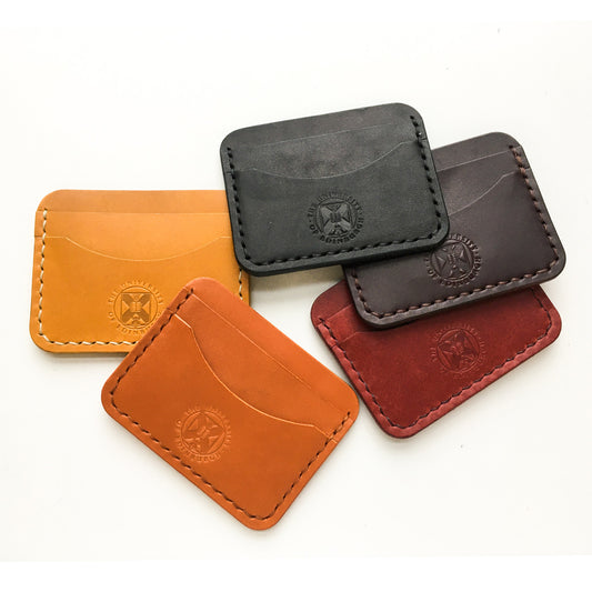 A collection of our leather card holders in mustard, tan, black , brown and red. Shot from the front demonstrating University crest embossing. 