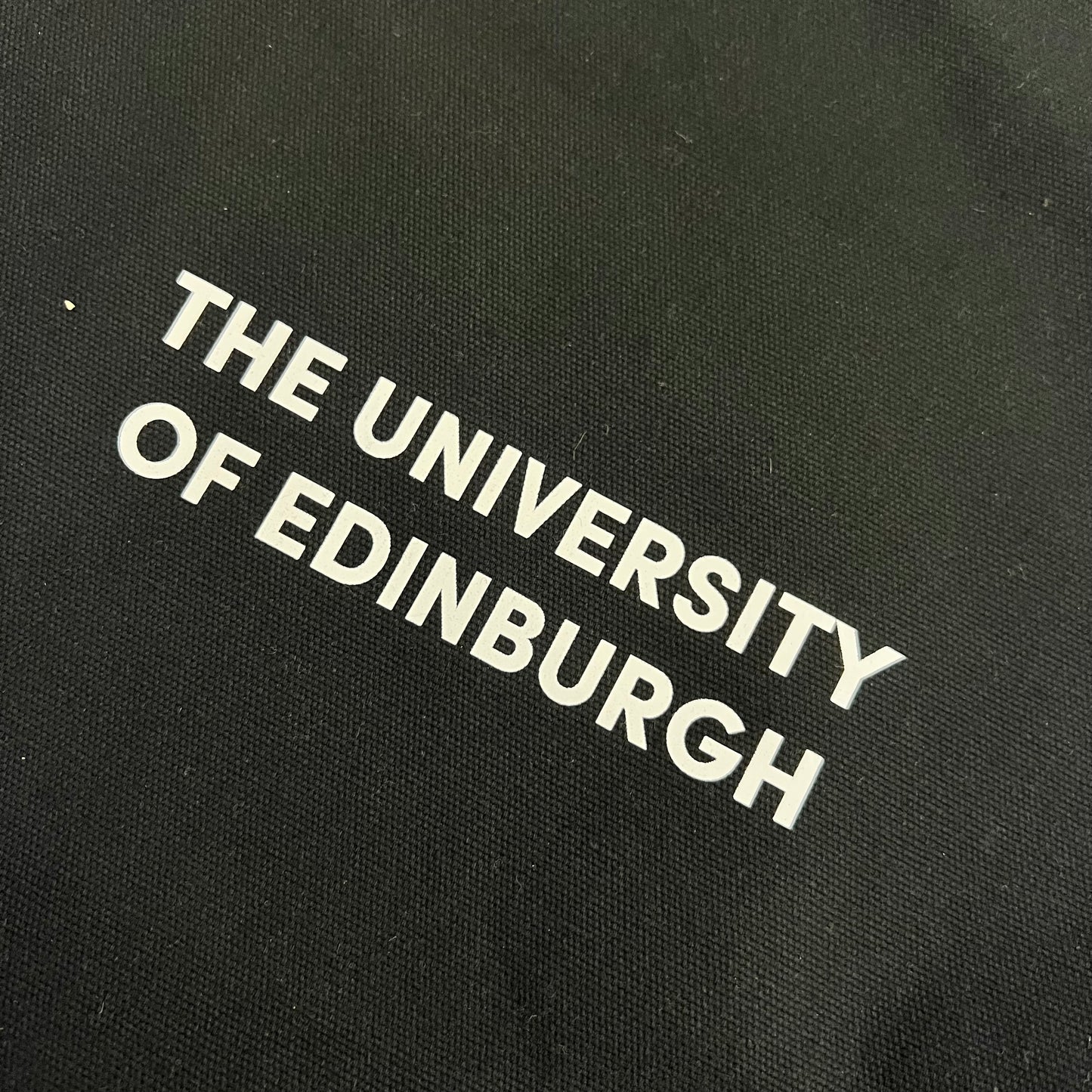 close up of black oversized tote bag with 'the university of edinburgh' in white print