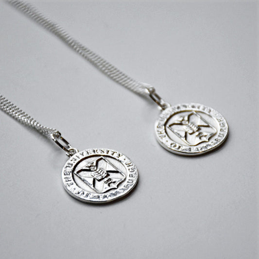 Two silver crest necklaces side by side