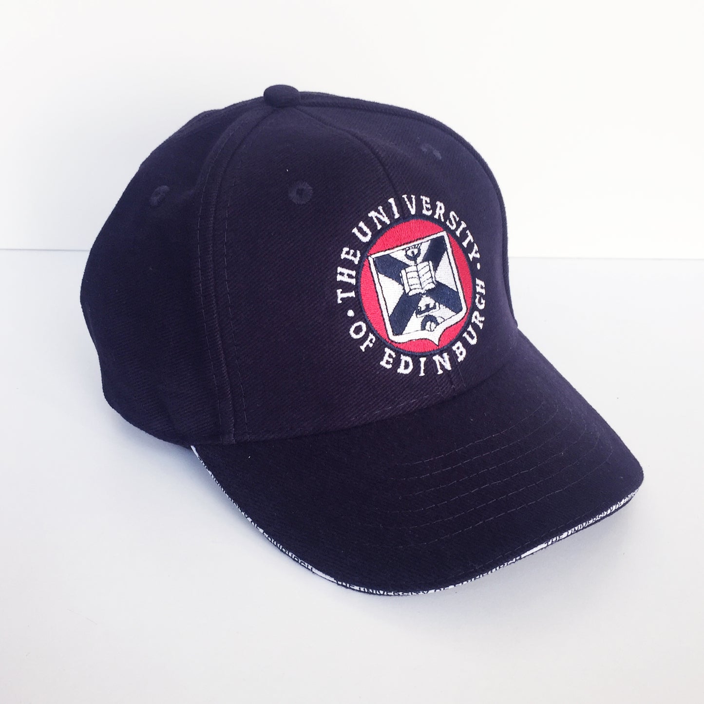 A navy baseball cap with full colour embroidery of the University crest on the front panel. 