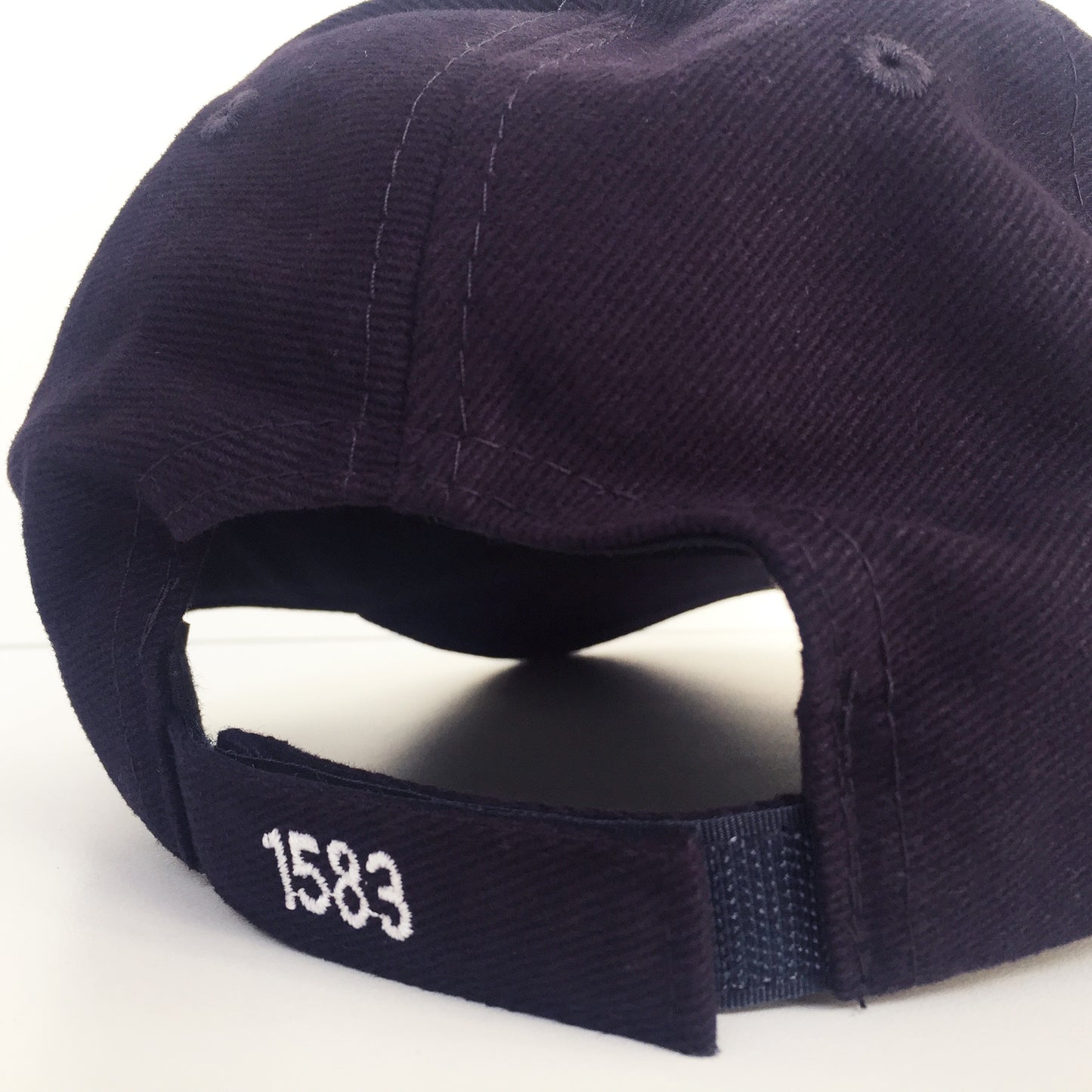 Close up of the adjustable Velcro strap with '1583' embroidery,
