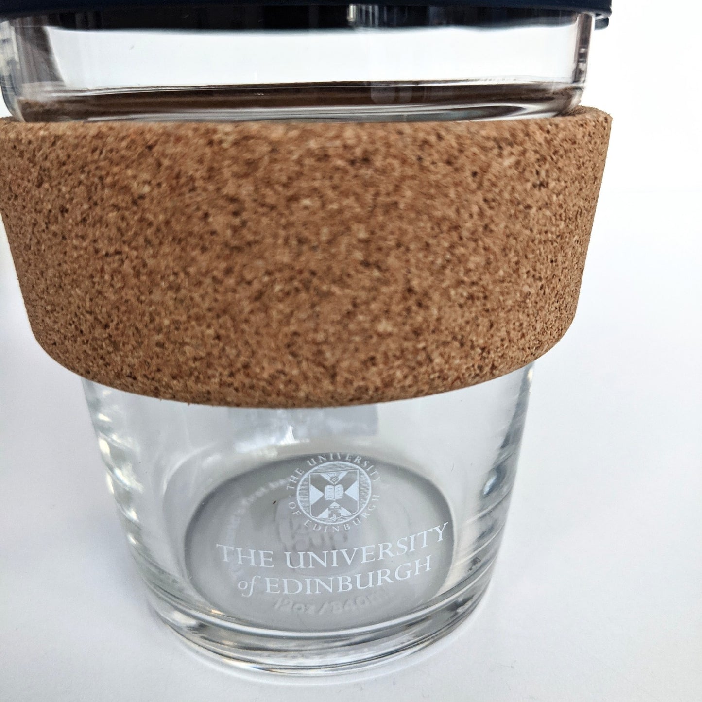 Close up of the University logo in white print on a Glass Keep cup Brew Cup