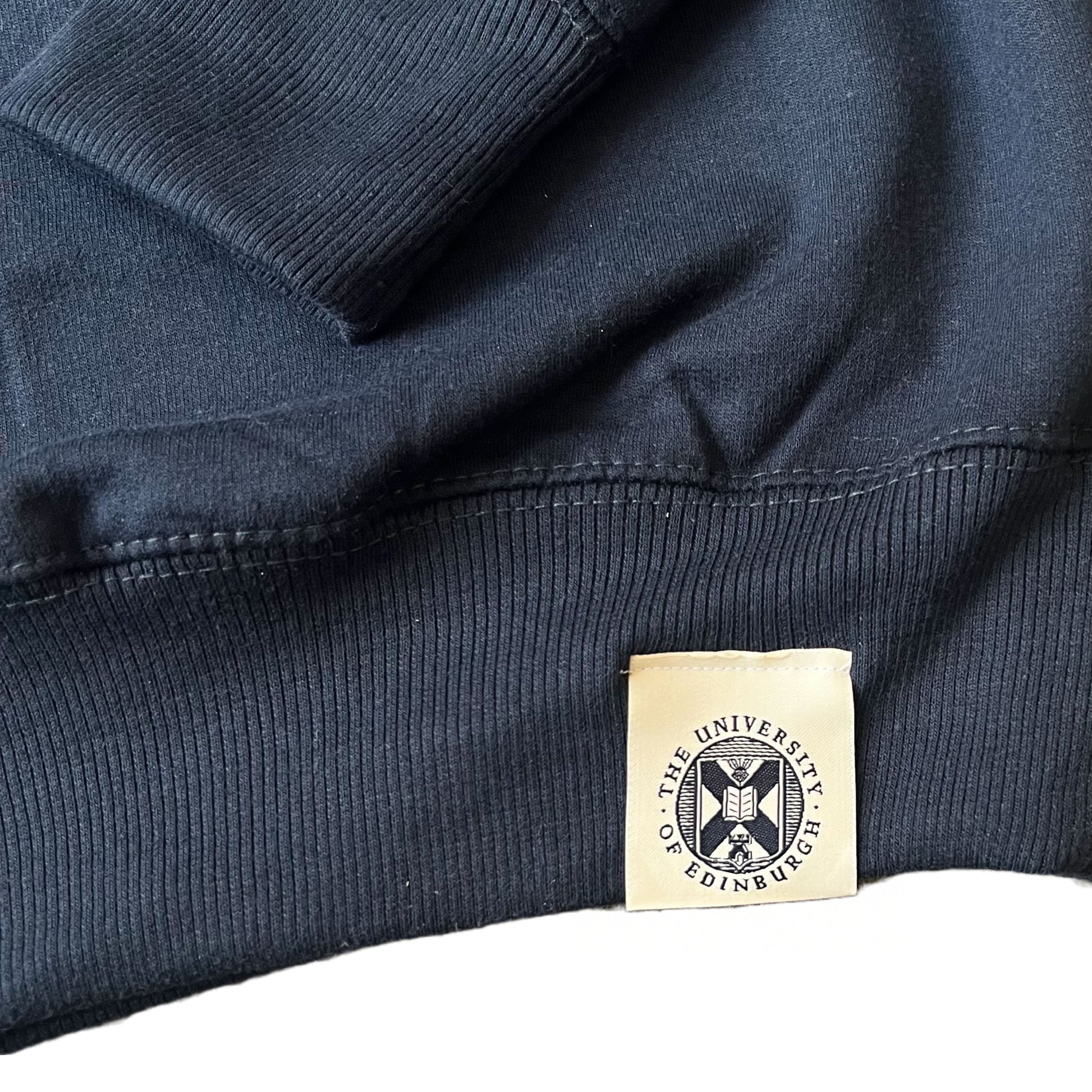 Close up of navy sweatshirt's University of Edinburgh crest stitched on the waistband
