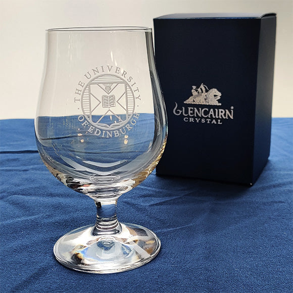 Crystal beer glass with University crest engraving next to a Glencairn branded gift box. 