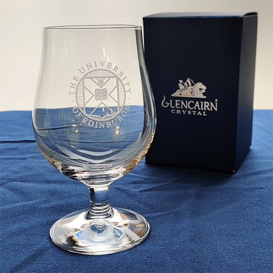 Crystal beer glass with University crest engraving next to a Glencairn branded gift box. 
