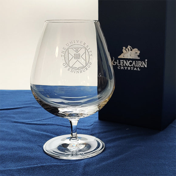 Crystal snifter glass featuring the University crest engraving next to a Glencairn gift box. 