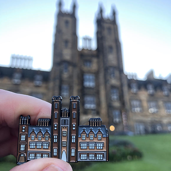 New College Pin Badge held against New College