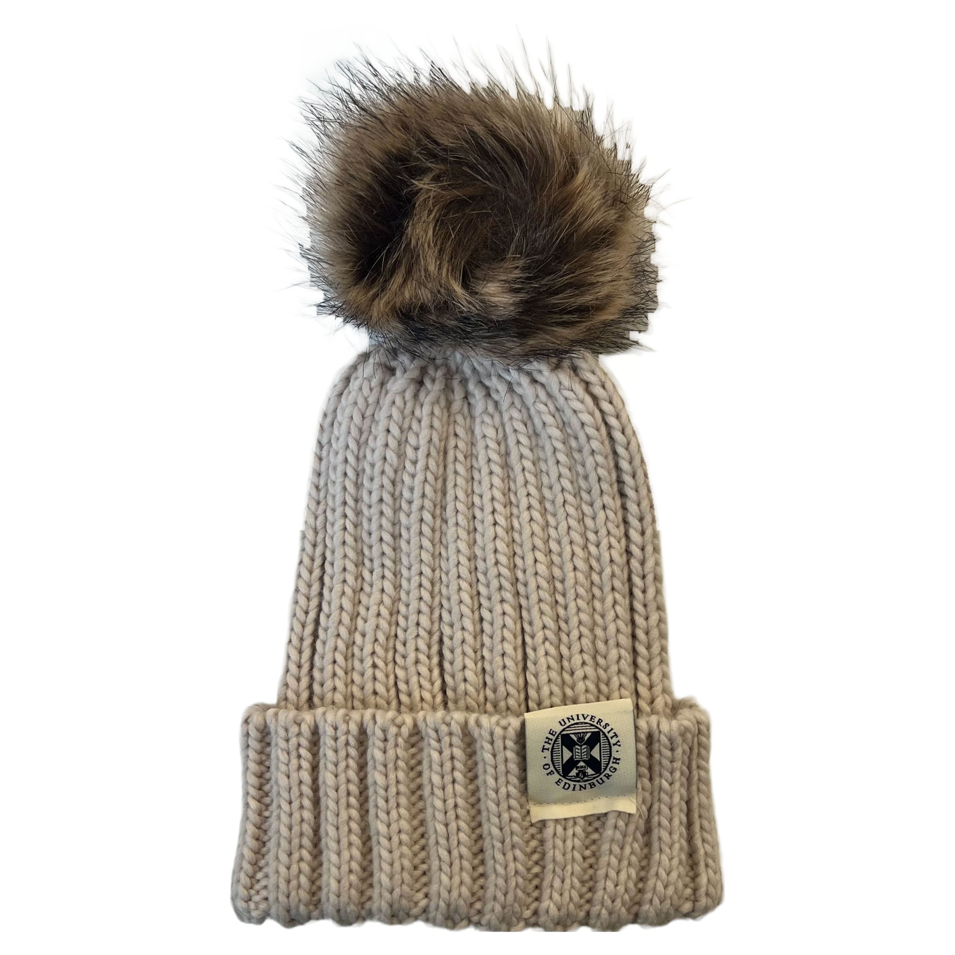 oatmeal beanie with brown pom pom and woven tag featuring university crest in navy