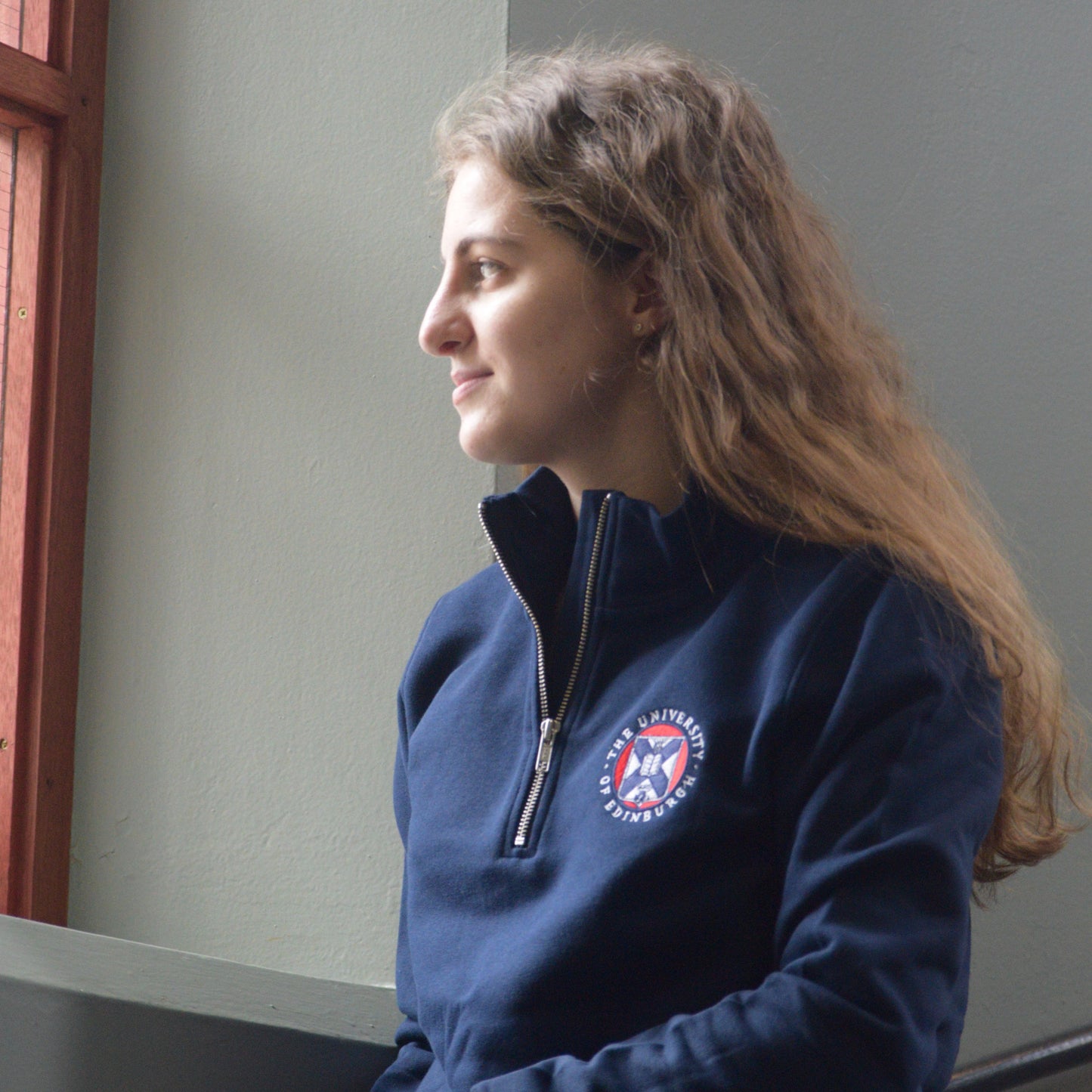 Model wearing navy blue quarter zip sweatshirt