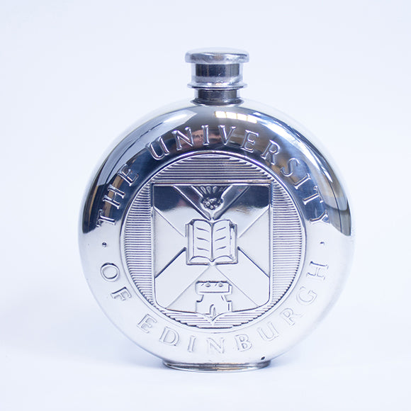 Front view of the round pewter hipflast with the embossed University crest visible