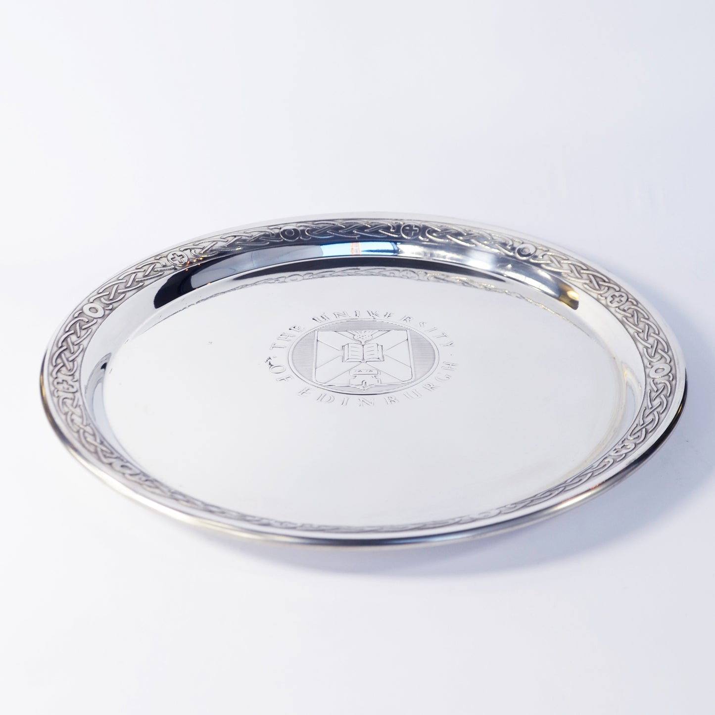 The large pewter salver seen diagonally from above, with the University crest visible