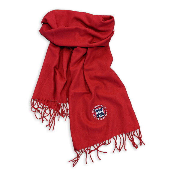 Red scarf with embroidered crest detailing and tassel trim. 