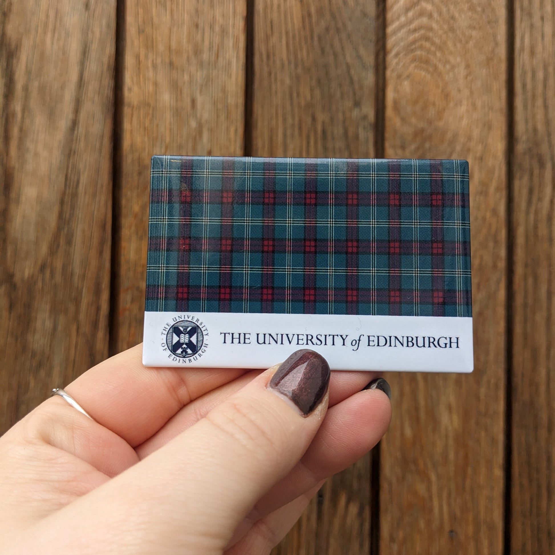 Model holding a rectangular magnet with a tartan design and The University of Edinburgh's crest