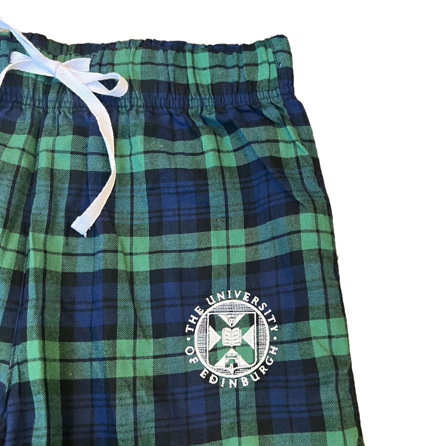 close up of navy and green tartan trousers with university crest embroidered in white