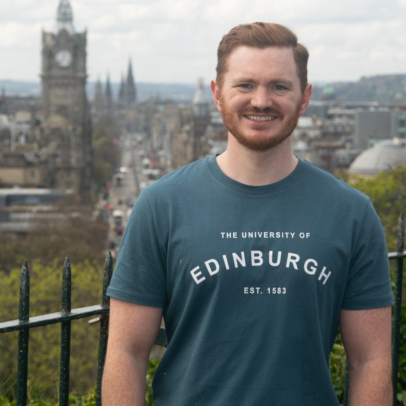 Our model wears the established design t-shirt in teal