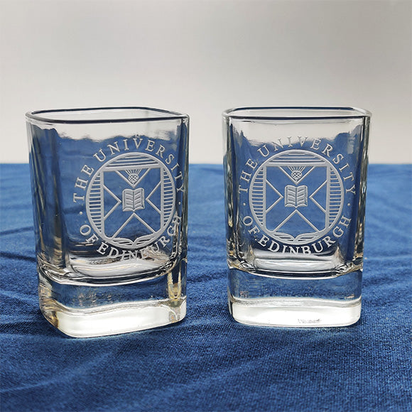 Two crystal shot glasses with University crest etching. 