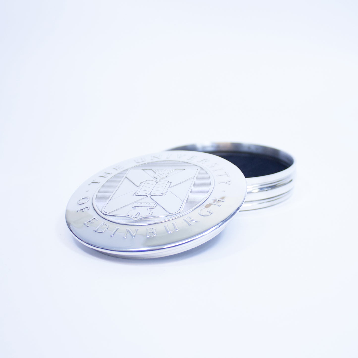 The pewter trinket box open, with the lid resting on the side of it.